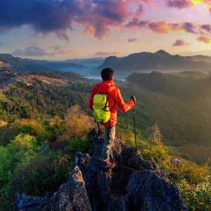 Backpacker standing on sunrise viewpoint at Ja Bo village, Mae hong son province, Thailand.